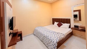 Een slaapkamer met een bed, een plafondventilator, een televisie en een spiegel.