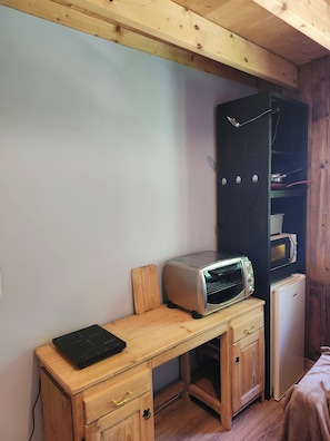 A compact kitchen with a wooden table, a toaster, a small refrigerator, and a microwave. - Private floor in a chalet in the heart of the Beaufortain mountains (Villard-sur-Doron)