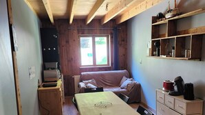 Une pièce de taille modeste comprenant un lit, une table à manger et un coin cuisine.