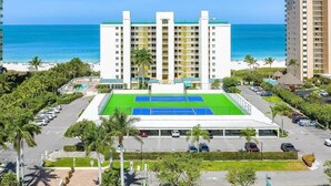A hotel with a rooftop pool, a beach view, and a parking lot. - Beachfront 3BR, 2BA Apollo condo with pool, WiFi, and heated Gulf views. (Marco Island)