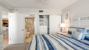 A bedroom with a bed, a nightstand, a lamp, a ceiling fan, and a closet with a sliding door. - Beachfront 3BR, 2BA Apollo condo with pool, WiFi, and heated Gulf views. (Marco Island)
