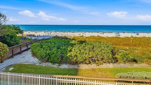 A beach with a wooden walkway and a white fence. - Beachfront 3BR, 2BA Apollo condo with heated pool and WiFi. (Marco Island)