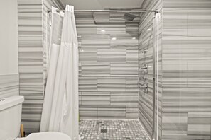 A shower with a curtain, a tiled floor, and a wall with a marble-like pattern. - Stylish 3BR Sleeps 6 Oasis | Near The Liberty Bell (Philadelphia)