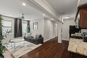 Un salon moderne avec un canapé, une table basse et un ventilateur de plafond.