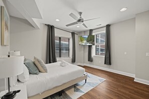 A bedroom with a bed, a ceiling fan, a TV, and a window with curtains. - Stylish 3BR Sleeps 6 Oasis | Near The Liberty Bell (Philadelphia)