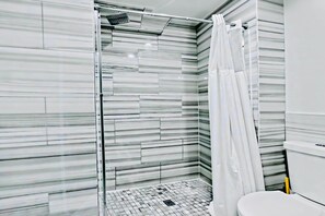 A modern bathroom with a glass shower enclosure, a tiled floor, and a white toilet. - Prime 3BR Philly Pad Fits 6 Guests Walk Everywhere (Philadelphia)