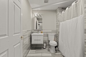 Une salle de bain avec des toilettes, un lavabo et un rideau de douche.