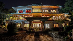 A multi-story building with a traditional architectural style, featuring a central courtyard and multiple windows. - Bamboo Retreat Hotel (Gangtok)