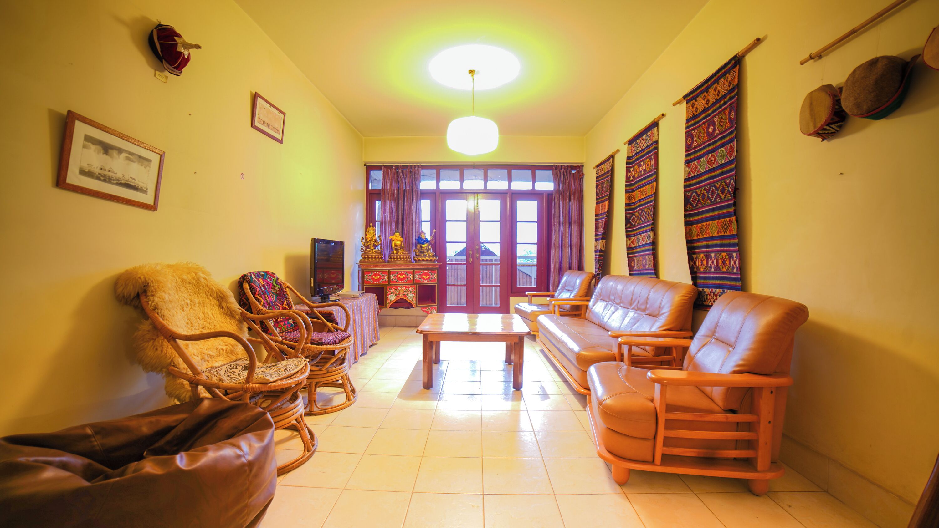 A living room with a sofa, chairs, a television, and a decorative altar.