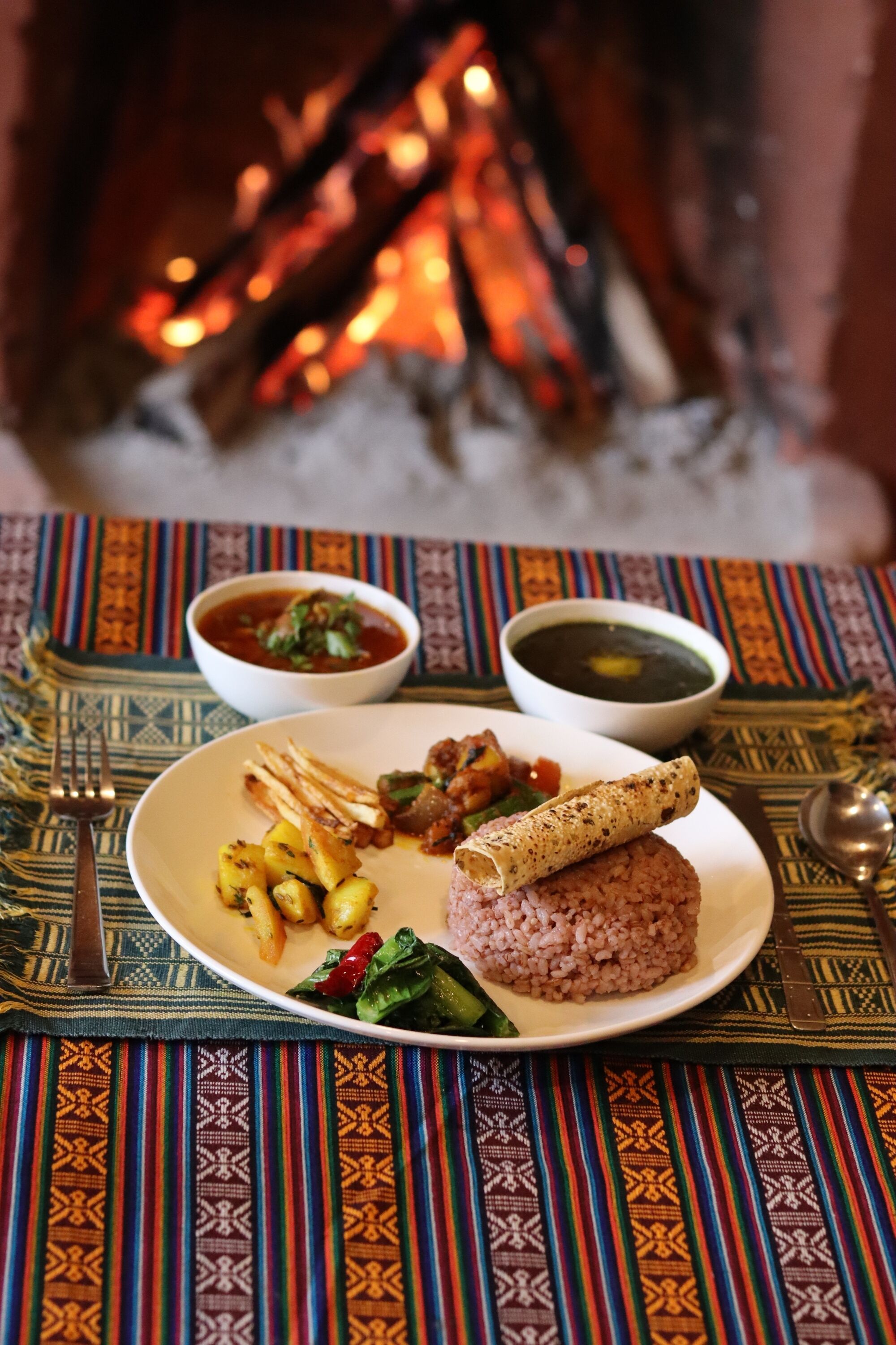 A plate of food with a fire in the background.