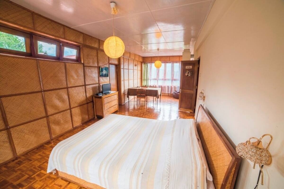 A room with a bed, a desk, a chair, and a window.