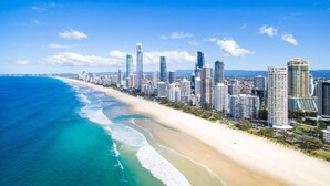 Un paisaje urbano costero con una playa y edificios altos.
