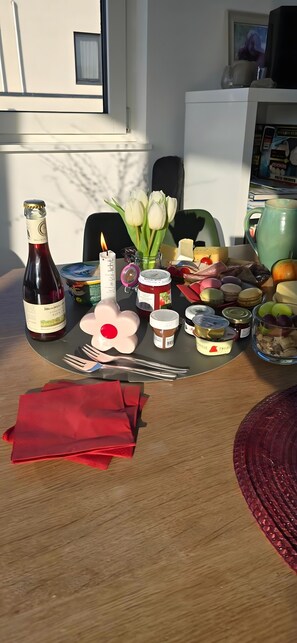 A table with food items, a bottle, and a candle. - City-Adjacent Guest Room in Esi’s Penthouse in Tübingen (Tübingen)