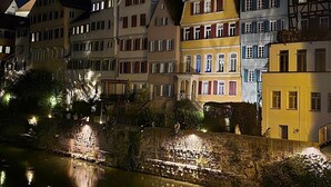 A row of traditional European buildings along a riverbank at night. - City-Adjacent Guest Room in Esi’s Penthouse in Tübingen (Tübingen)