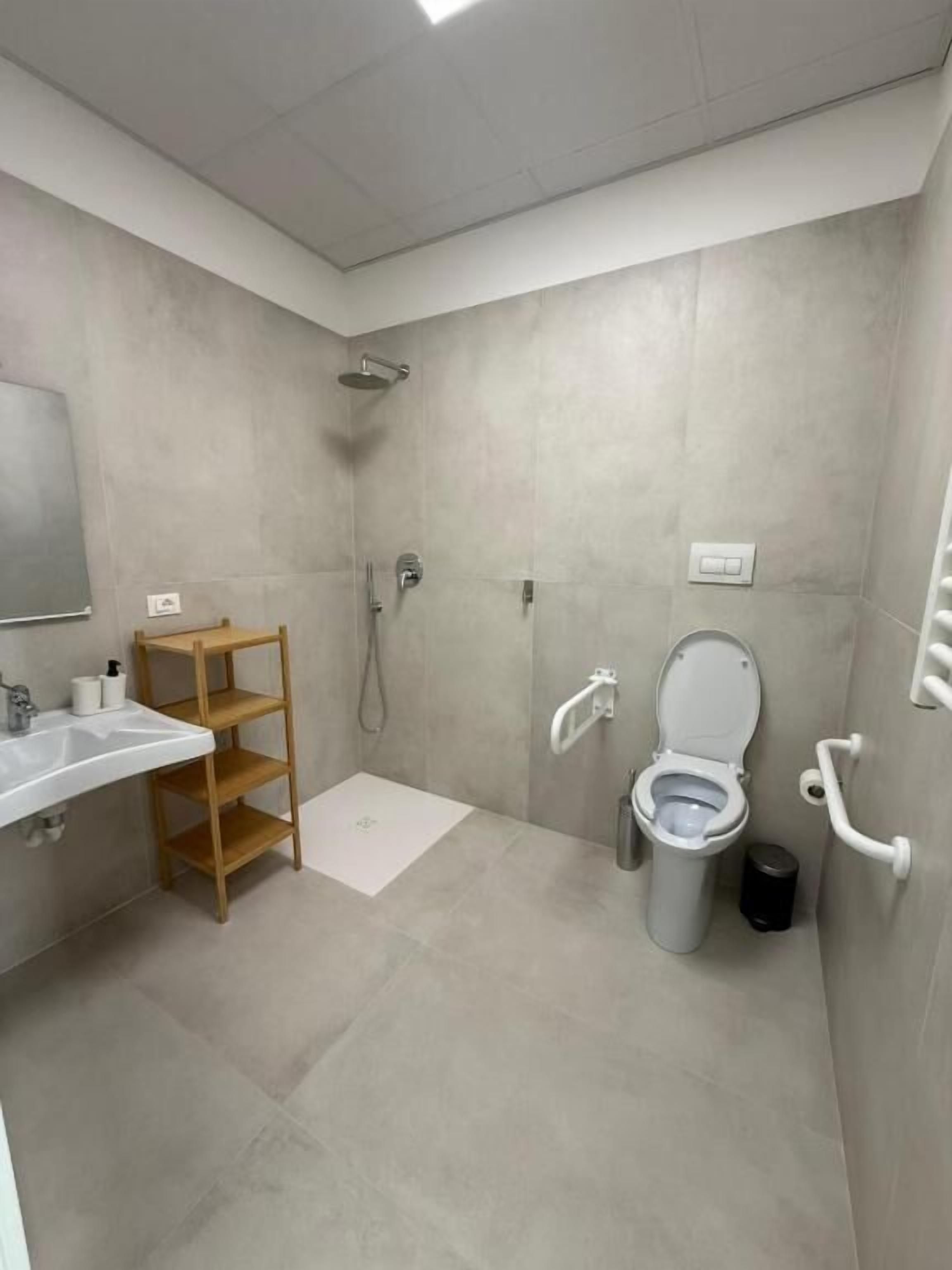 A modern bathroom with a shower, toilet, and sink.