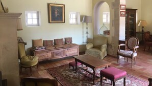 Un salon chaleureux avec un canapé, des fauteuils, une table en bois et un tapis à motifs.