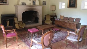 Un salon traditionnel avec une cheminée, des meubles en bois et un tapis à motifs.