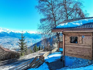 Eine Holzhütte mit Blick auf schneebedeckte Berge.