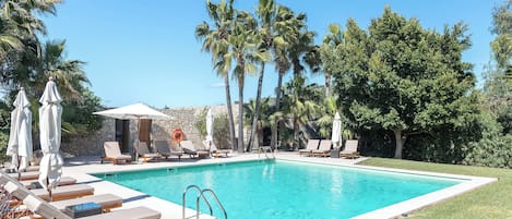 Una piscina cubierta, una piscina al aire libre de temporada, sombrillas