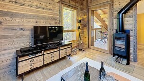 En hyggelig træindretning med tv, træskab og pejs.