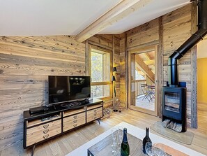A cozy wooden interior with a TV, wooden cabinet, and a fireplace. - Ceiba - Les Gets - Near the center (Les Gets)