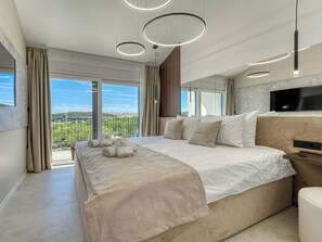 Une chambre d’hôtel moderne dotée d’un grand lit, d’une télévision et d’un balcon offrant une vue sur la ville.