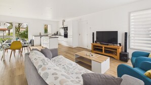 Un salon moderne avec un canapé, un téléviseur et une table basse en bois.