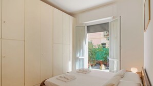 A bedroom with a bed, a wardrobe, and a window with a view of the outside. - Beautiful apartment for 4 guests with A/C, WIFI, TV and terrace (Santa Margherita Ligure)