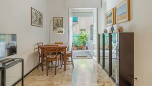 A hallway with a dining table, chairs, a TV stand, and a cabinet. - Beautiful apartment for 4 guests with A/C, WIFI, TV and terrace (Santa Margherita Ligure)