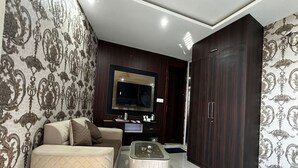 A modern living room with a sofa, a coffee table, a TV, and a wardrobe.