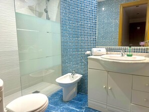 Ein Badezimmer mit Toilette, Bidet, Waschbecken und Spiegel.
