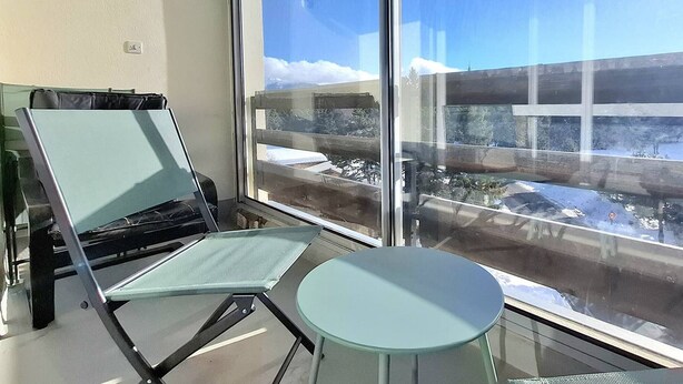 A balcony with a view of a snowy landscape and a building. - Cozy T2 Cabin with enclosed loggia (Bolquère-Pyrénées 2000)