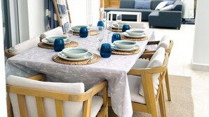 An outdoor dining area with a table set for four, surrounded by wooden chairs. - Modern villa with private garden and pool. Ideal for families or small groups. (Las Palmeras)