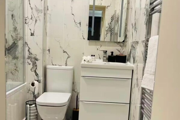 A bathroom with a toilet, a sink, and a mirror. - Near Hampden - Parking - Wifi - Sleeps 6 (Glasgow)