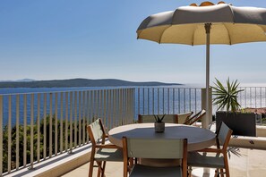 An outdoor patio with a round table, chairs, and a large umbrella. - Premium 3BR Villa Vista Divina w/ Pool (Zavala)
