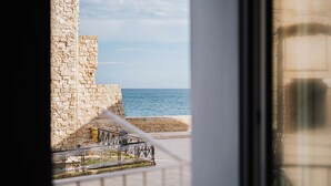 A stone wall with a metal railing overlooking the sea. - Seafront Apartments by Carlo V Castle, Monopoli Old Town - HelloAPULIA Al Castello di Amec (Monopoli)