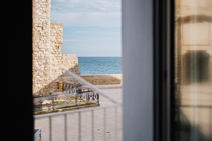 Un muro in pietra con ringhiera metallica che si affaccia sul mare.