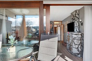 Un interior moderno con una mesa de vidrio, una pared de piedra y un televisor.