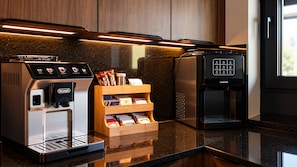 A modern kitchen with a coffee machine, a coffee dispenser, and a wooden storage unit for coffee pods.