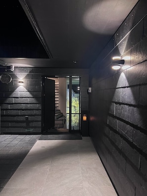 A modern hallway with a staircase leading to a bright interior. - Villa Tauris - Lake Lucerne - Private Spa & Natural Pool (Emmetten)
