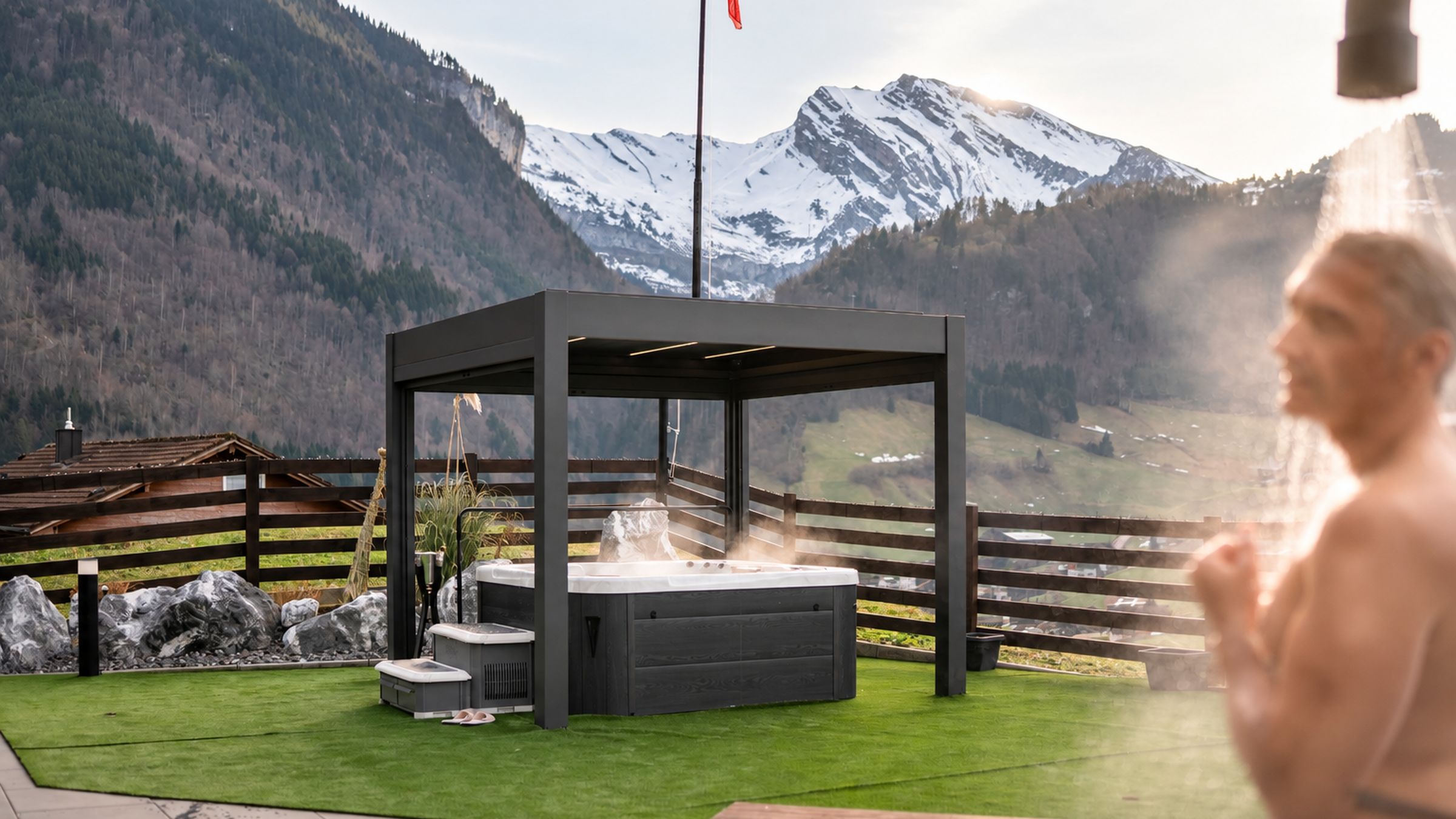 A hot tub with a wooden deck and a mountain backdrop.