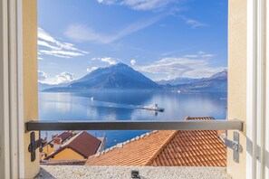 A balcony with a view of a mountain, calm lake, and boats. - Breathtaking Lake View by Varenna Holidays (Varenna)