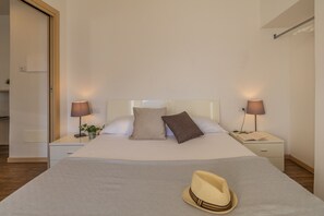 Een keurig opgemaakt hotelkamer met een bed, twee nachtkastjes en lampen.