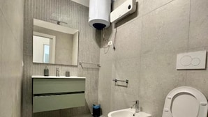 Un baño moderno con inodoro, bidé y lavamanos.