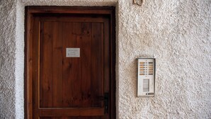 A wooden door with a sign, a textured wall, and a numbered plaque. - Casa Eleonora (Zogno)