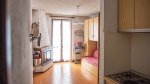 A compact living space with a kitchenette, a bed, and a small bathroom. - Casa Eleonora (Zogno)
