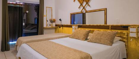 Quarto de hotel com duas camas, um espelho grande, um aparelho de ar condicionado e uma janela com vista.