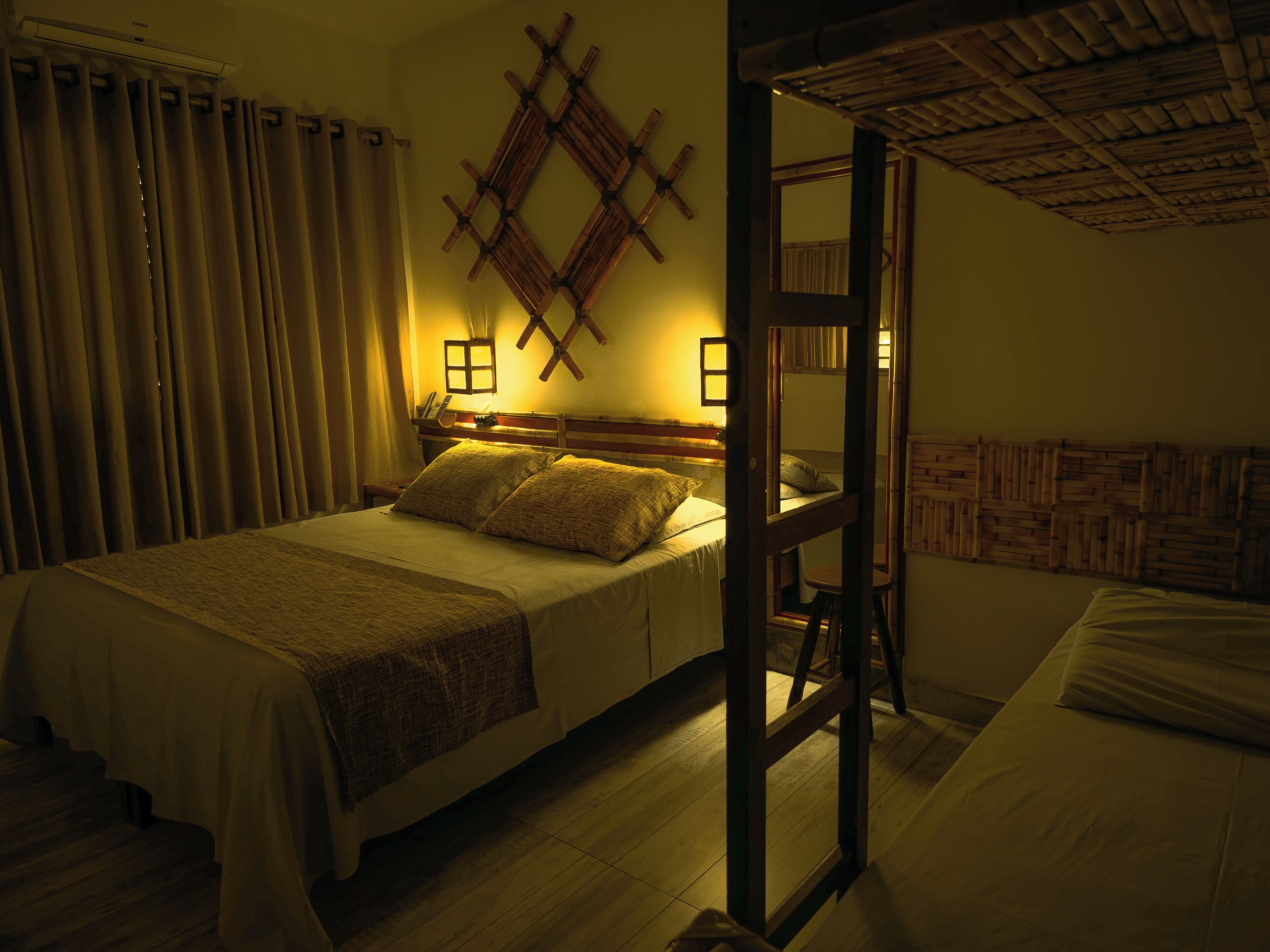 A room with a bed, a wooden headboard, a nightstand, and a wall-mounted light fixture.