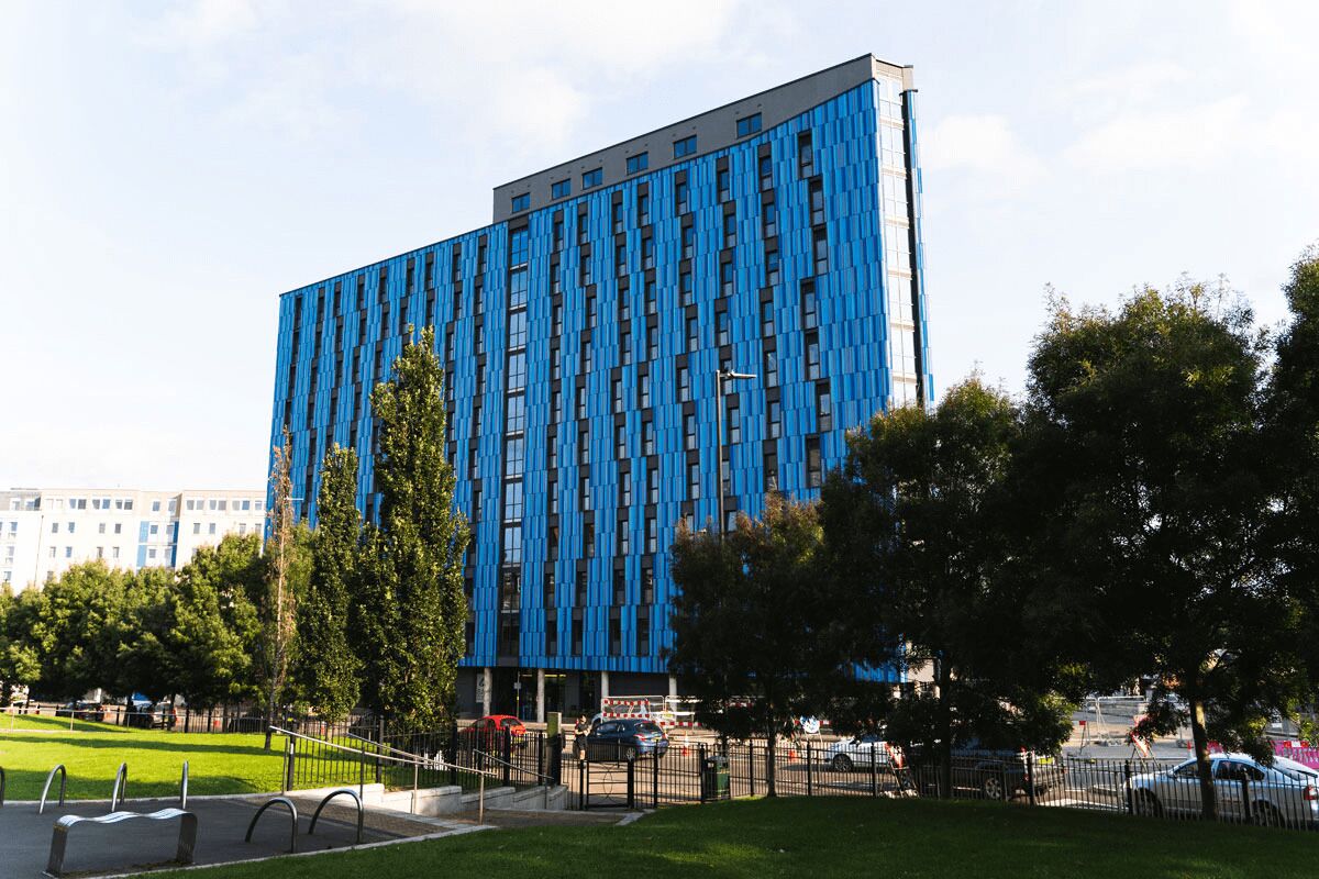 A modern building with a blue facade and vertical window patterns.