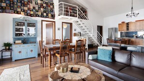 Ein geräumiges Wohnzimmer mit Treppe, Holzesstisch und einer gemütlichen Sitzecke.